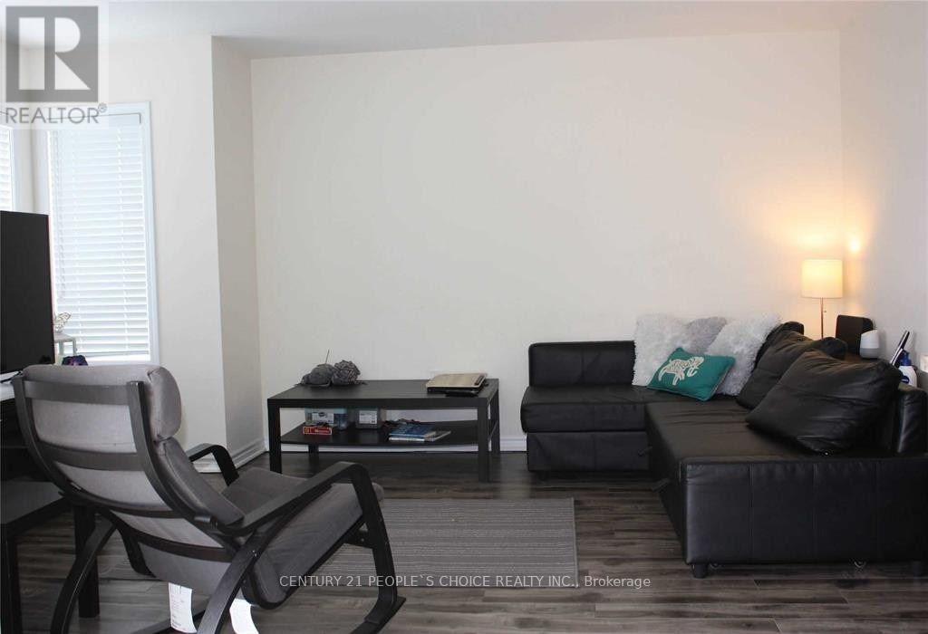 A living room with a black couch, a grey chair, and a coffee table.