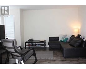 A living room with a black couch, a grey chair, and a coffee table.