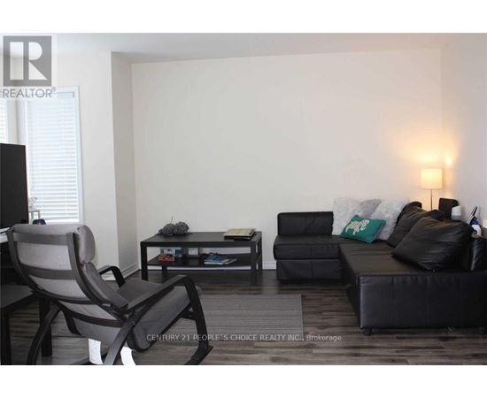 A living room with a black couch, a grey chair, and a coffee table.