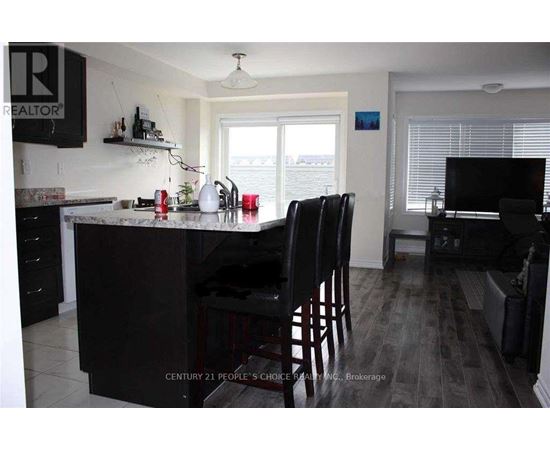 A kitchen with a black counter and chairs.
