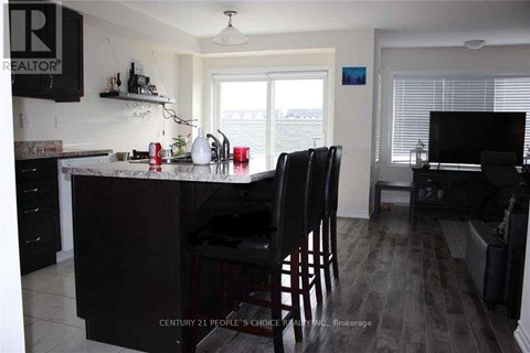 A kitchen with a black counter and chairs.
