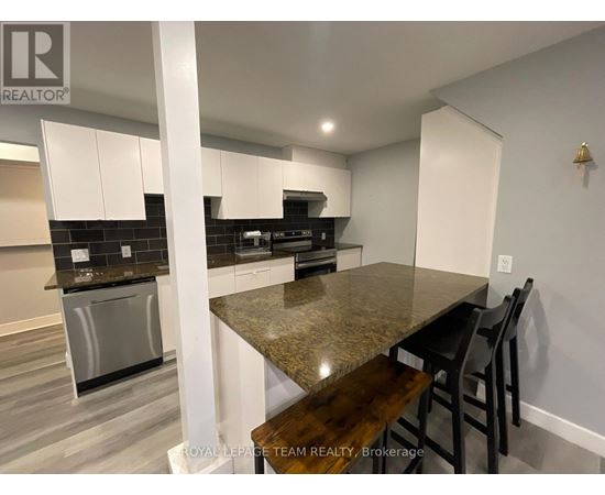 A kitchen with a granite countertop and stainless steel appliances.