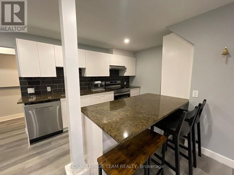 A kitchen with a granite countertop and stainless steel appliances.