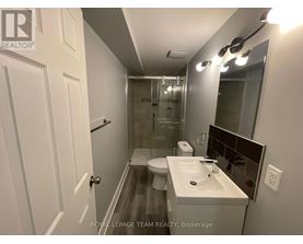 A bathroom with a toilet, sink, and mirror.