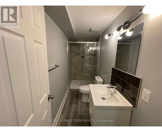 A bathroom with a toilet, sink, and mirror.