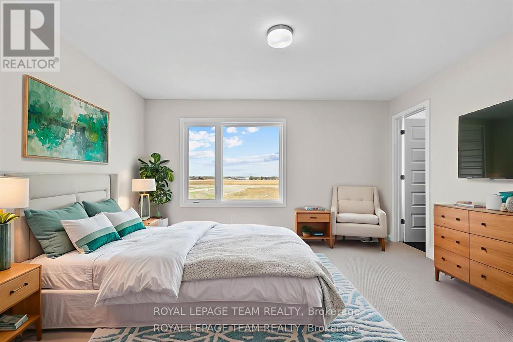 A bedroom with a large bed, a chair, and a painting on the wall.
