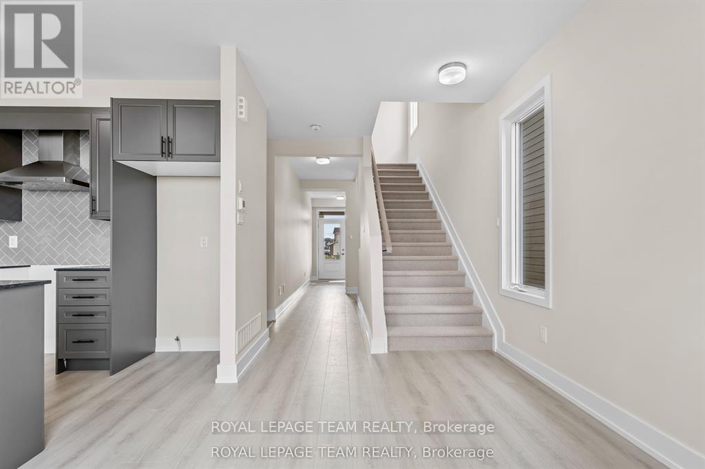 A spacious hallway with a staircase leading to the second floor.