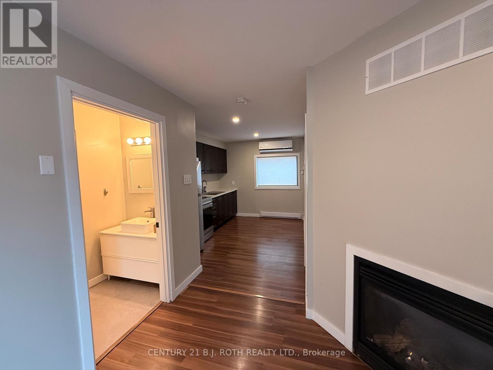 A bathroom with a fireplace and a window.