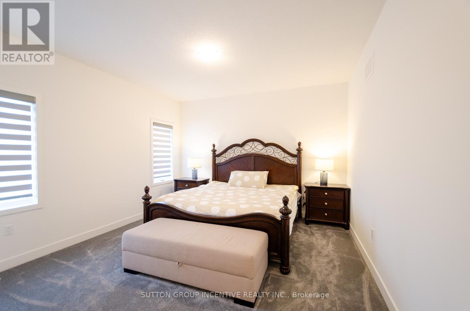 A bedroom with a large bed and a bench at the foot of the bed.