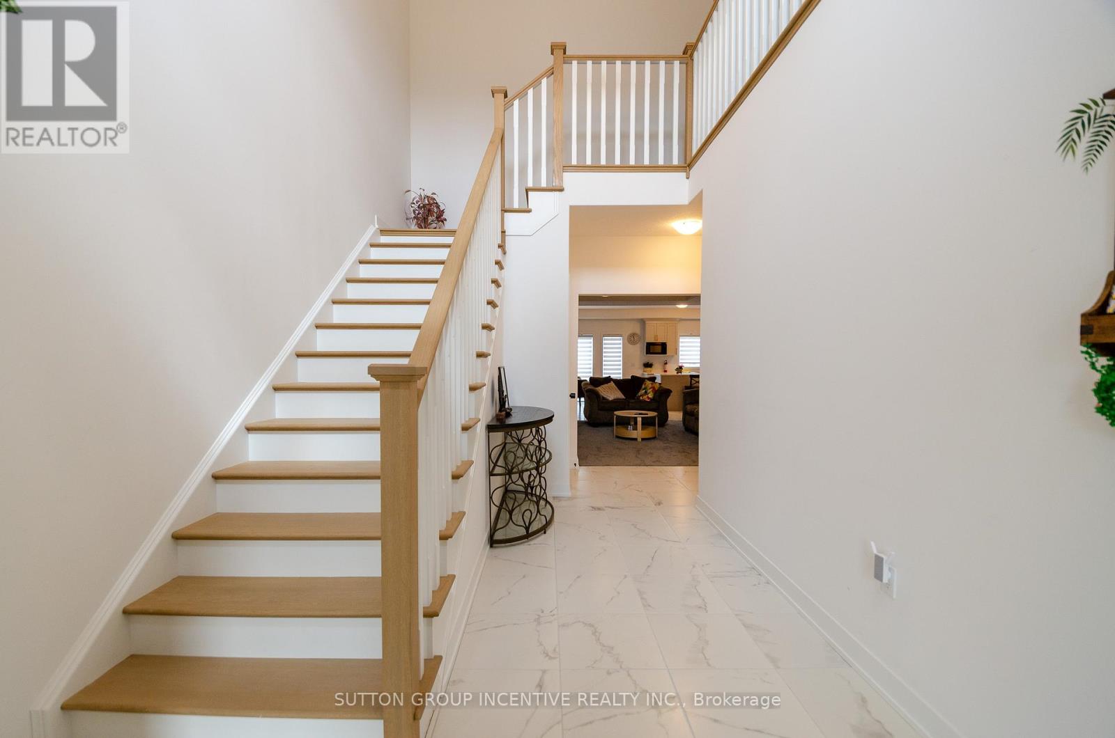 A hallway with a staircase leading to a living room.