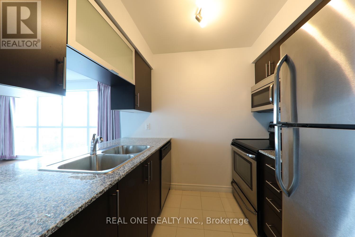 A kitchen with a sink and a refrigerator.