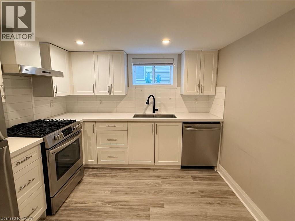 A kitchen with white cabinets and a black stove top.