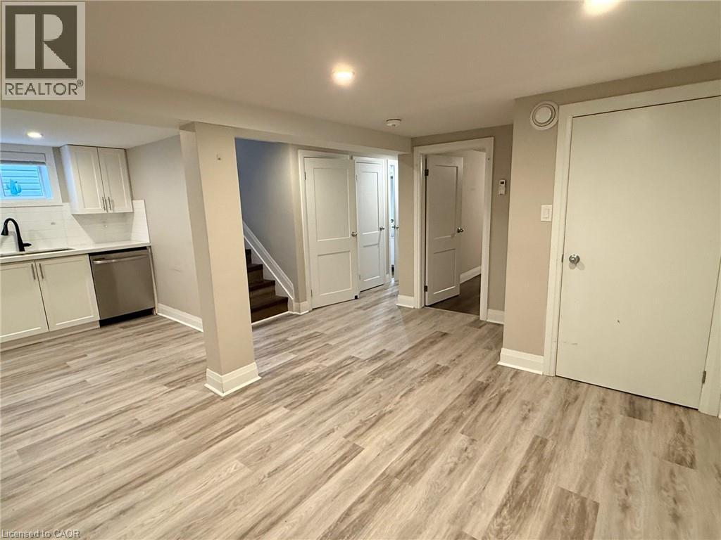 A spacious room with wood flooring and white walls.