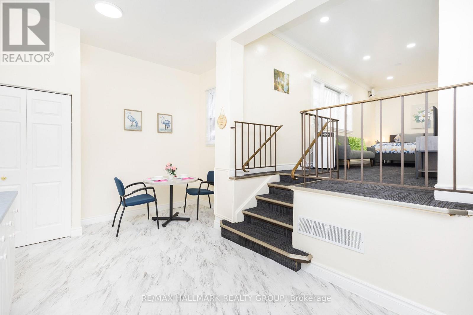 A dining room with a table set for two and a staircase leading to the bedrooms.