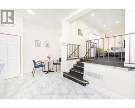A dining room with a table set for two and a staircase leading to the bedrooms.
