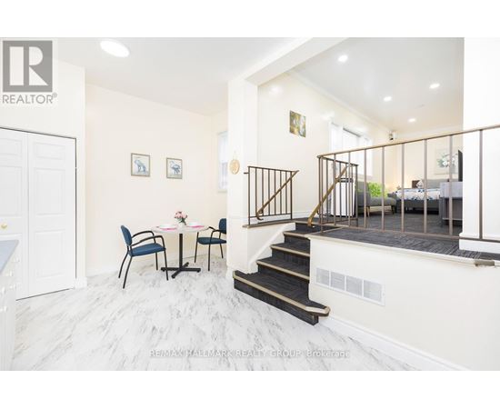 A dining room with a table set for two and a staircase leading to the bedrooms.