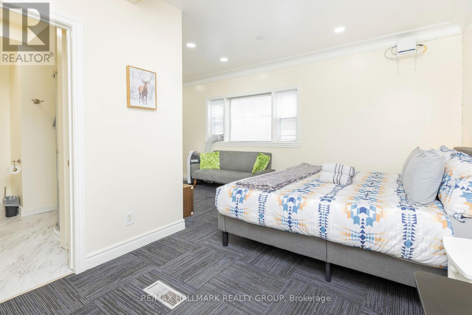 A bedroom with a bed and a couch in it.