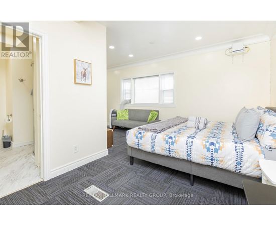 A bedroom with a bed and a couch in it.