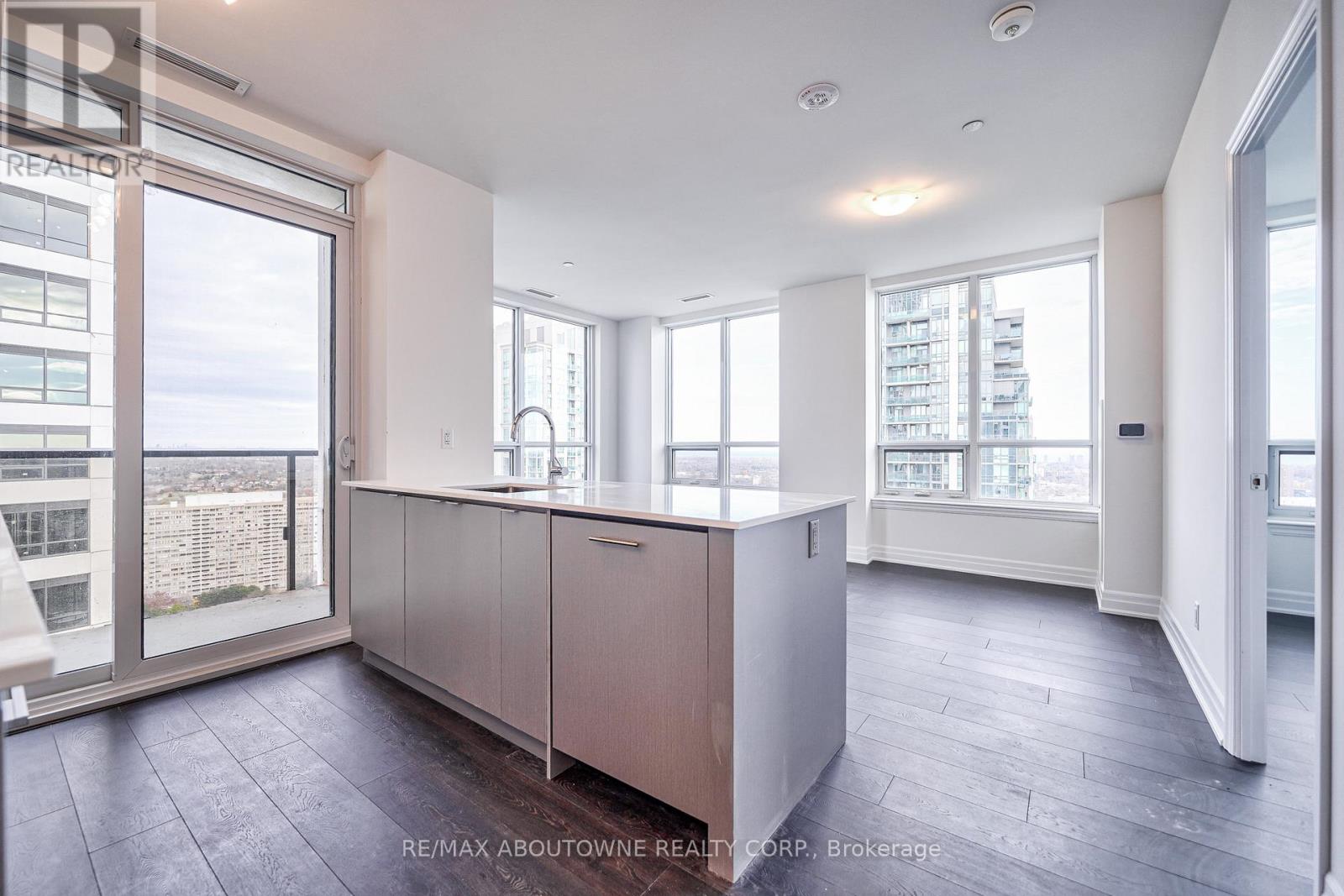 A spacious room with a large window and a view of the city.