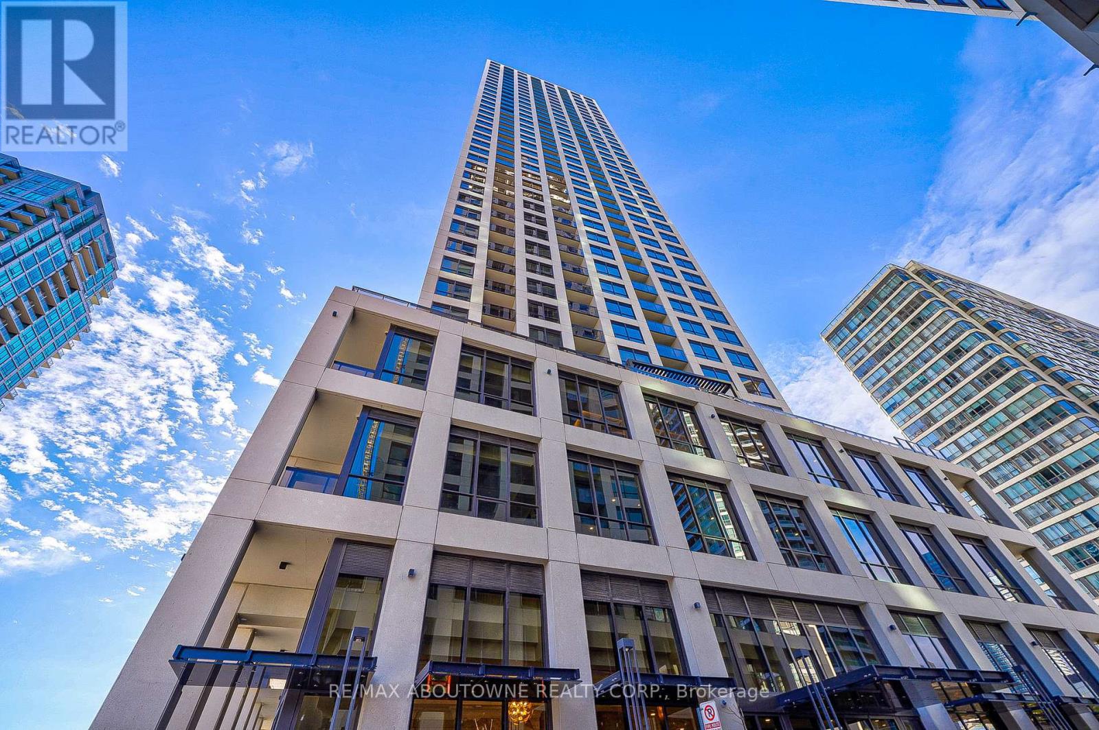 A tall white building with blue sky and clouds in the background.