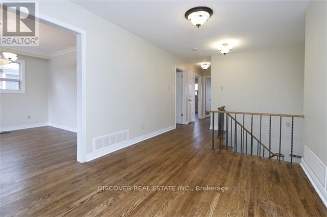 A spacious room with wooden floors and white walls.