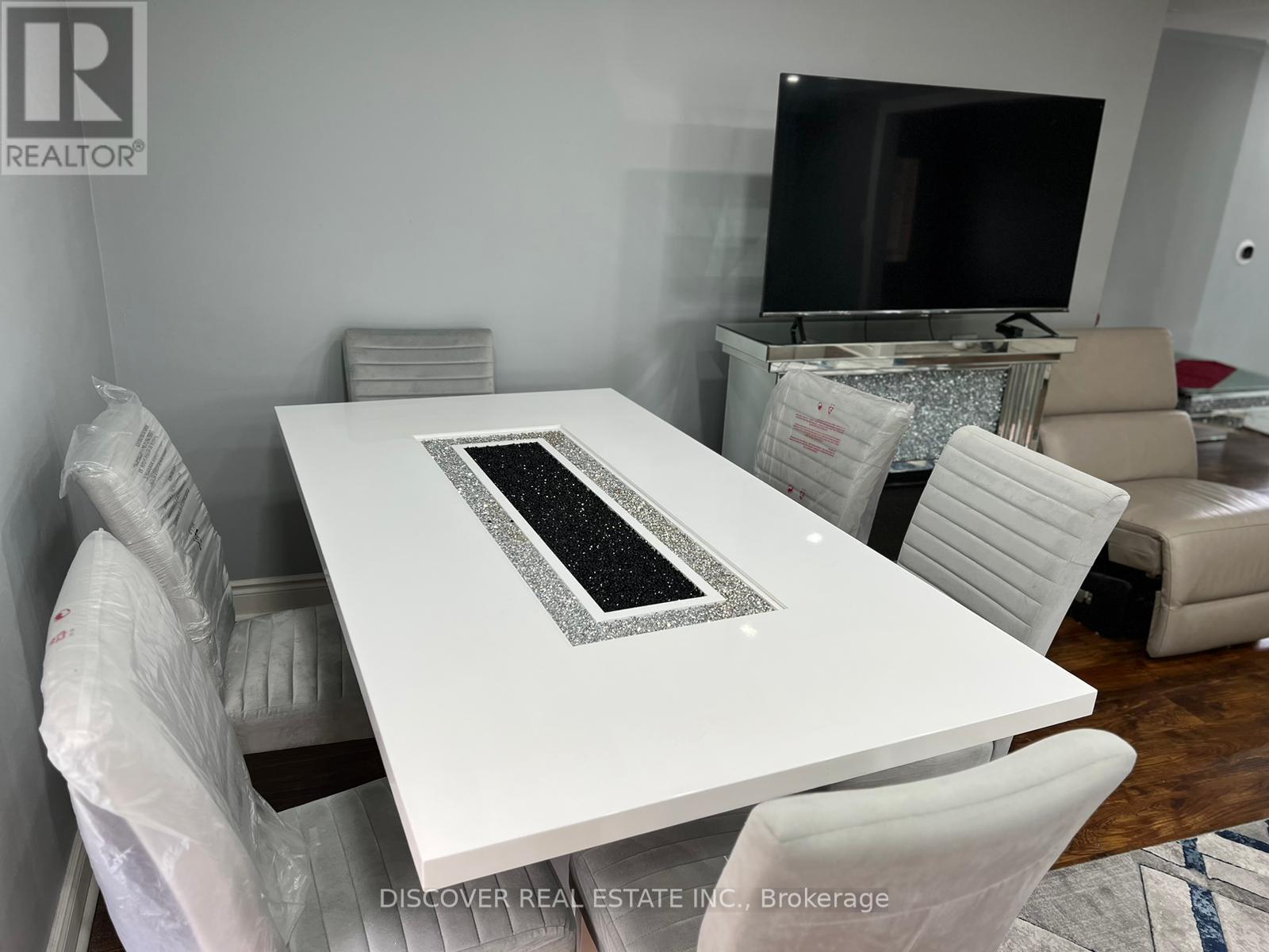A modern dining room with a white table and chairs.
