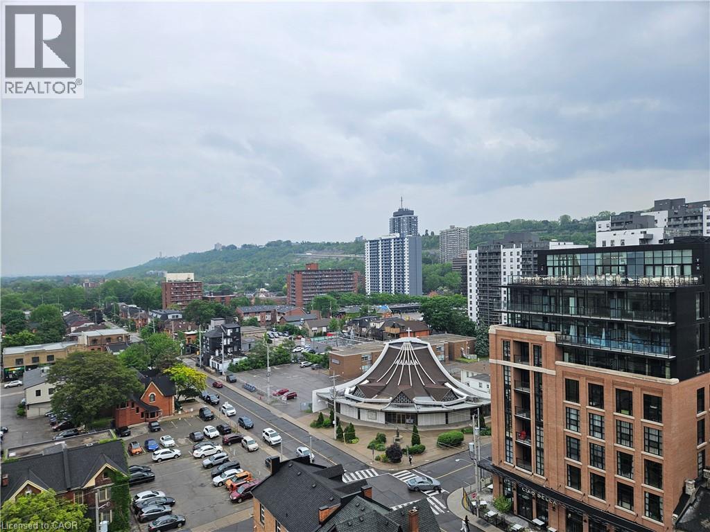 A cityscape with a mix of modern and older buildings, a parking lot, and a gazebo-like structure in the center.