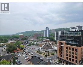 A cityscape with a mix of modern and older buildings, a parking lot, and a gazebo-like structure in the center.