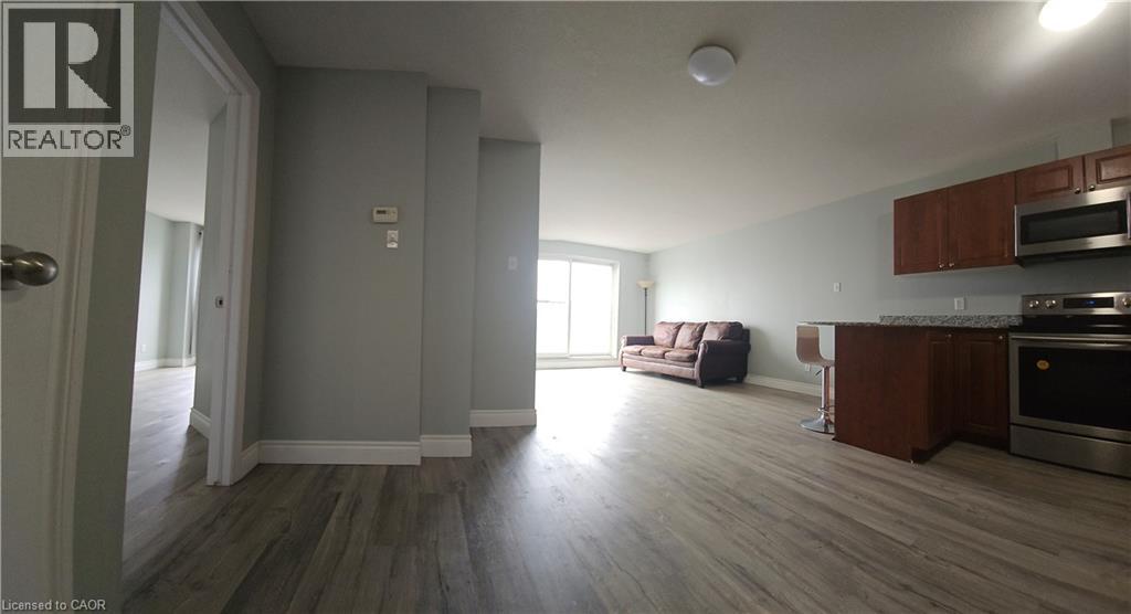 A living room with a couch and a kitchen area in the background.