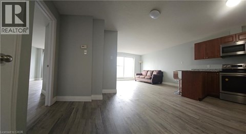 A living room with a couch and a kitchen area in the background.