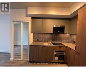 A kitchen with wooden cabinets and a black microwave.