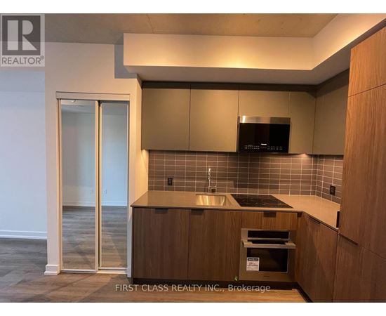 A kitchen with wooden cabinets and a black microwave.