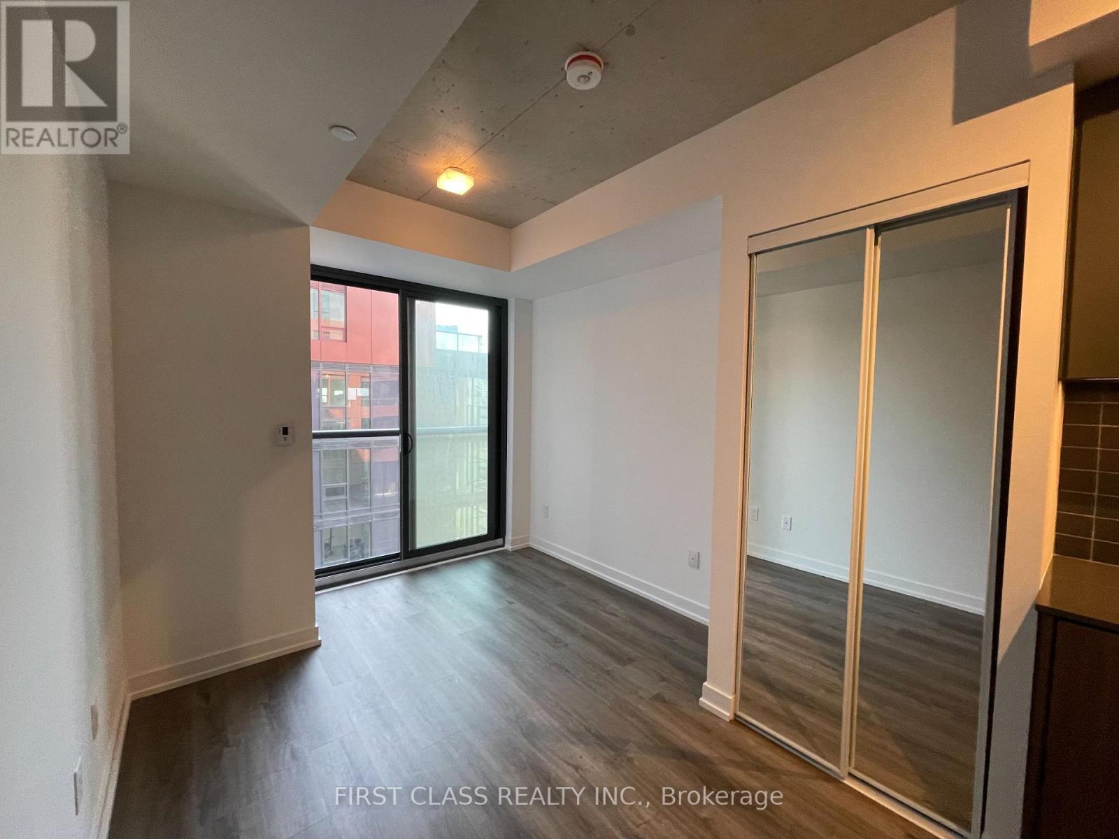 A room with a sliding glass door leading to a balcony.