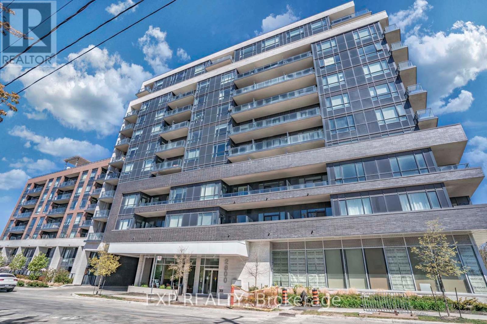 A modern multi-story residential building with a clear sky in the background.