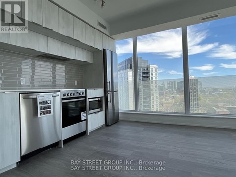 A modern kitchen with a view of the cityscape outside the window.