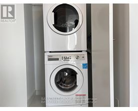 A white washing machine with the door open is in a room.
