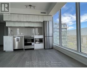 A modern kitchen with a view of the cityscape outside the window.