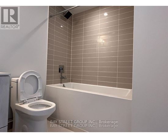 A white toilet sits next to a bathtub in a bathroom.