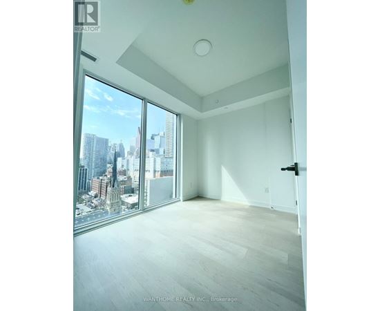A spacious room with a view of the cityscape outside the large window.