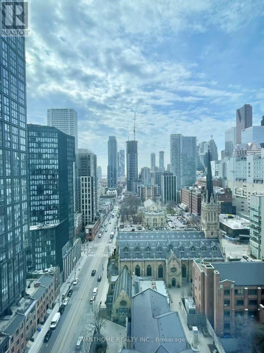 A cityscape with a church in the foreground and skyscrapers in the background.