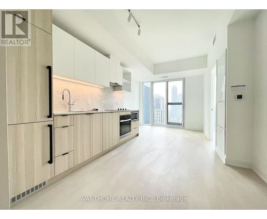 A modern kitchen with wooden cabinets and a large window.