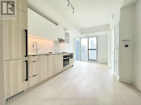 A modern kitchen with wooden cabinets and a large window.