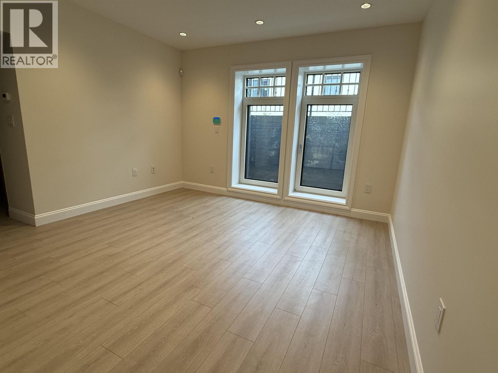 A room with a window and wooden flooring.
