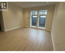 A room with a window and wooden flooring.