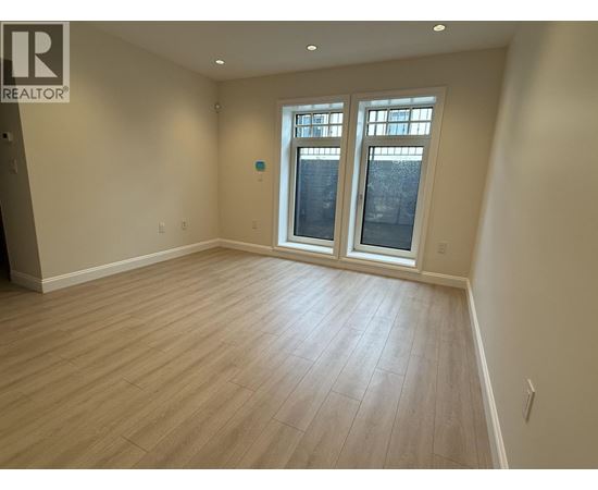 A room with a window and wooden flooring.