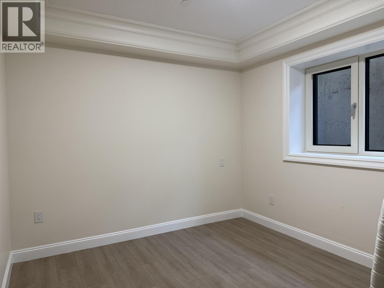 A room with a window and wooden flooring.