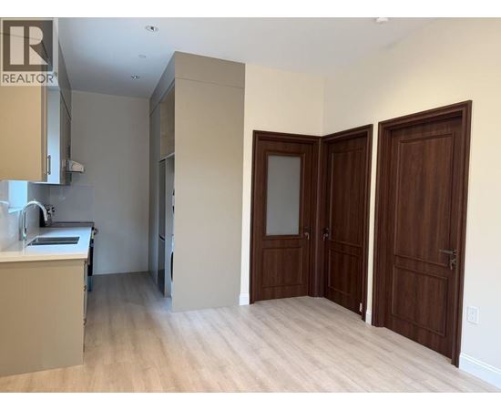 A realtor sign is on the wall in an empty room.