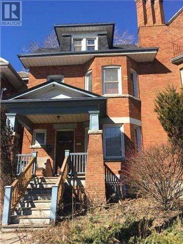 A red brick house with a blue front porch.