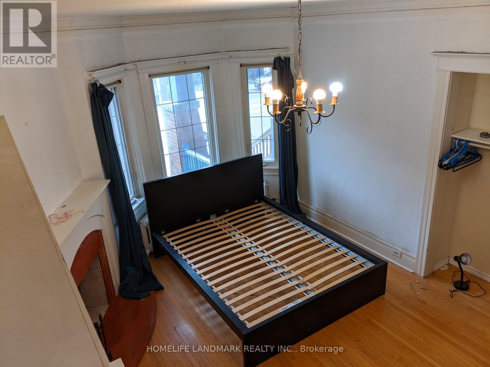 A bedroom with a large bed and a chandelier.