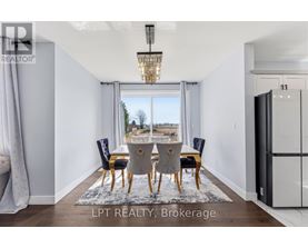 A dining room with a table set for four and a view of the outdoors through the window.